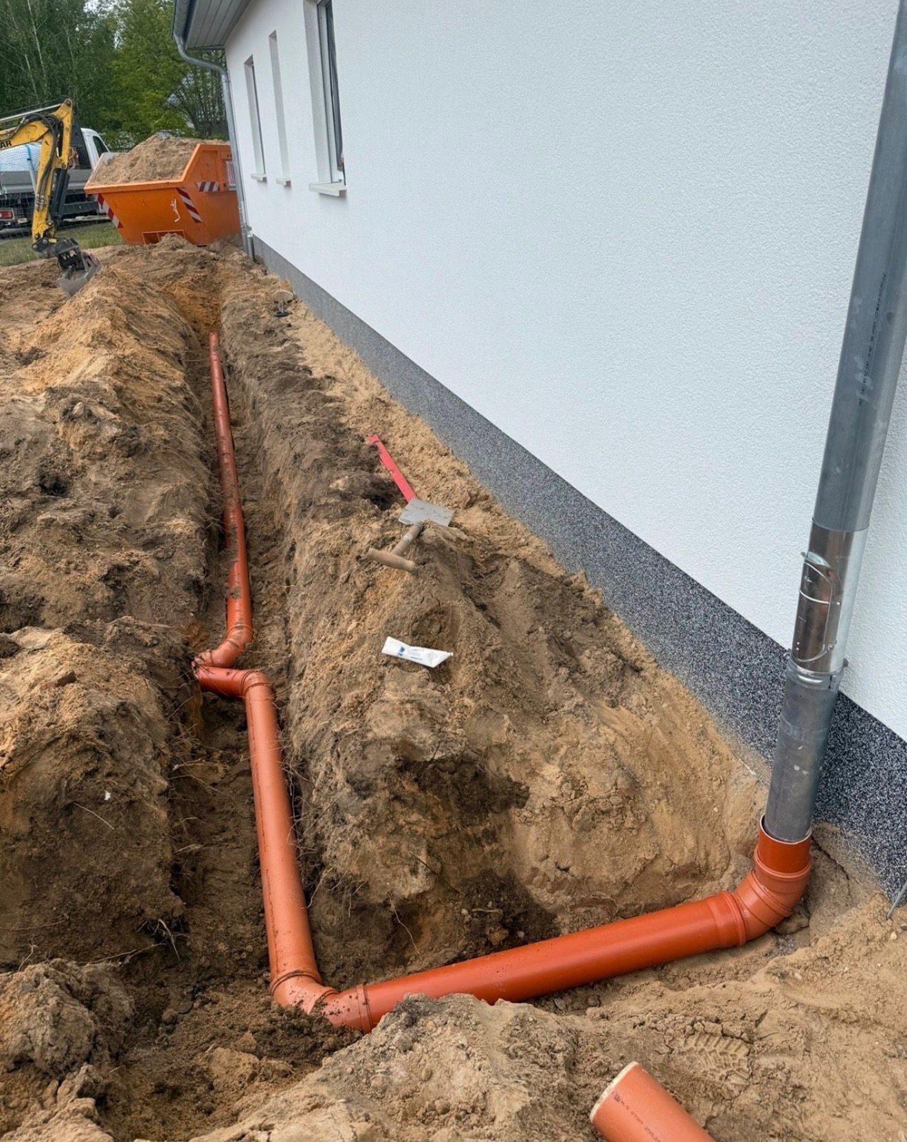 Frisch verlegte KG-Rohre entlang der Hauswand