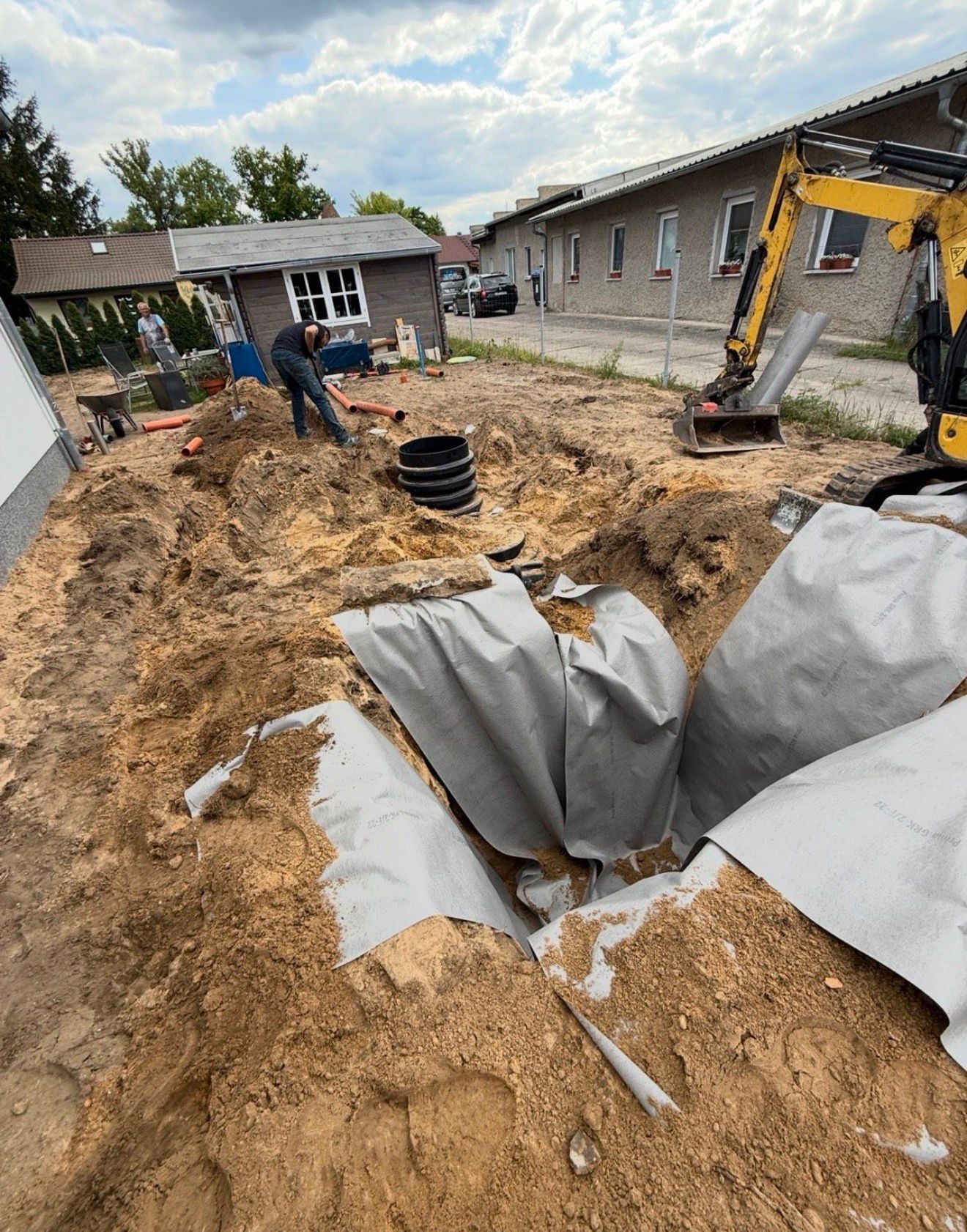 Vorbereitete Grube mit Vliesbettung vor dem Einsetzen des Tanks
